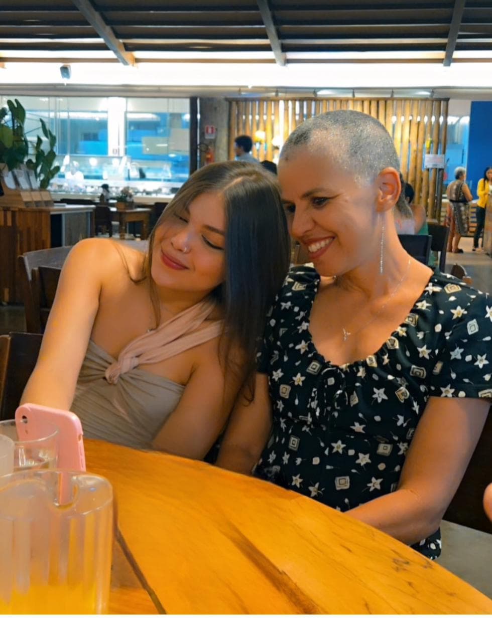Eduarda e Leila Campelos abraçadas e sorrindo em um restaurante